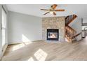 Living room with fireplace, stairs, and light wood flooring at 1699 S Trenton St # 77, Denver, CO 80231