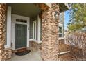 Inviting front entrance with stone columns and a green door at 16 Whitehaven Cir, Highlands Ranch, CO 80129