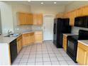 Kitchen with light wood cabinets, black appliances, and tile floor at 624 Pitkin Way, Castle Rock, CO 80104