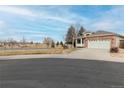 House exterior showcasing a two-car garage and a view of a green space at 16523 Prairie Flower Pl, Parker, CO 80134