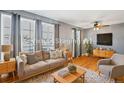 Virtually staged living room with hardwood floors, large windows, and a neutral color palette at 1626 S Sheridan Blvd, Denver, CO 80232