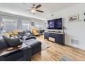 Bright living room with hardwood floors, comfortable seating, and large TV at 2095 S Knox Ct, Denver, CO 80219