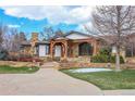 Brick and stone exterior with a landscaped yard and inviting walkway at 5230 Bow Mar Dr, Littleton, CO 80123