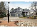 Two-story house with gray siding, three-car garage, and landscaping at 1366 Teton Pt, Lafayette, CO 80026