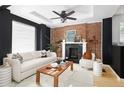Living room features exposed brick wall, fireplace, and white sofa at 1473 Yates St, Denver, CO 80204
