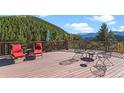 Large deck with mountain views, chairs, and fire pit at 420 Chinook Rd, Idaho Springs, CO 80452