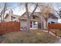 Tan bi-level townhome with red door, steps, and small fenced yard at 2970 W 119Th St, Westminster, CO 80234