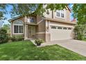 Two-story house with beige siding, a double car garage, and manicured lawn at 10830 Milliken St, Parker, CO 80134