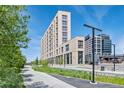 Contemporary multi-story building with adjacent green space and city views at 3575 Chestnut Pl # 704, Denver, CO 80216