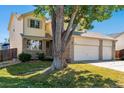 Two-story house with three-car garage and a mature tree in the front at 2272 S Fundy Way, Aurora, CO 80013