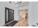 Bright and airy entryway with hardwood floors and staircase at 9353 Wiltshire Dr, Highlands Ranch, CO 80130