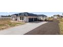 A large, modern home with a three-car garage and a long driveway at 29775 E 162Nd Ave, Brighton, CO 80603