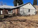 Rear of house with brick and siding and a small patio at 2792 S Macon Cir, Aurora, CO 80014
