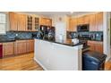 Kitchen with island, stainless steel appliances, and wood cabinetry at 299 N Catawba Ct, Aurora, CO 80018
