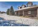 House exterior showcasing front porch and snow covered landscaping at 4805 Moonshine Ridge Trl, Parker, CO 80134