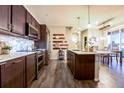 Modern kitchen with dark wood cabinets, stainless steel appliances, and island at 1786 W 66Th Ave, Denver, CO 80221