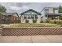 Front view of a charming bungalow with a brick wall at 3637 Lowell Blvd, Denver, CO 80211