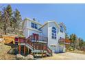 Two-story home exterior with a double-car garage and expansive decks at 11770 Leavenworth Dr, Conifer, CO 80433