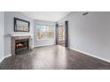 Living room with fireplace, hardwood floors, and sliding door to balcony at 5775 W Atlantic Pl # 303, Lakewood, CO 80227