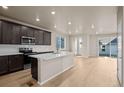 Spacious kitchen featuring dark cabinetry, island, and stainless steel appliances at 21239 E 62Nd Ave, Aurora, CO 80019