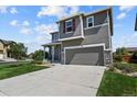 Two-story house with gray siding, a two-car garage, and well-manicured lawn at 1303 Yellow Granite Way, Monument, CO 80132