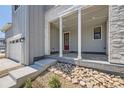 Covered front porch with stone accents and a red front door at 11077 Star Fall St, Littleton, CO 80125