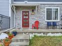 Inviting front entry with red door, stone accents, and porch at 635 Stonebridge Dr, Longmont, CO 80503