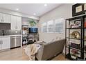 Modern kitchen with white cabinets, stainless steel appliances, and gray backsplash at 2466 S Delaware St # 2, Denver, CO 80223