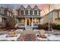 Two-story home with gray siding, white trim, and a charming front porch at 9084 E 37Th Ave, Denver, CO 80238