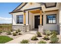 Front entrance of a modern farmhouse with stone accents and landscaping at 24113 E 36Th Pl, Aurora, CO 80019