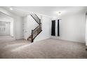 Bright living room with plush carpet and a staircase at 7844 S Elk St, Aurora, CO 80016