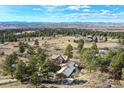 Stunning aerial view of a secluded home nestled among trees with mountain views in the distance at 5519 Ponderosa Dr, Parker, CO 80134