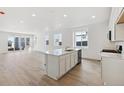 Open concept kitchen with island, stainless steel appliances, and white cabinets at 9723 Ceylon St, Commerce City, CO 80022