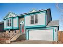 Two-story house with teal siding, red door, and attached garage at 11241 W 104Th Ave, Broomfield, CO 80021