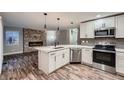 Modern kitchen with white cabinets, stainless steel appliances, and a large island at 2221 Mattive Pl, Brighton, CO 80601