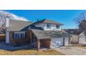 Brick two-story house with a large front yard and attached garage at 596 Fox Hunt Cir, Highlands Ranch, CO 80126