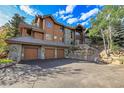 Mountain home exterior boasts stone accents and a three-car garage at 3864 Valley Dr, Evergreen, CO 80439