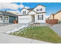 Inviting two-story home with white siding, black accents, and a neatly landscaped yard at 1562 Farmstead St, Brighton, CO 80601