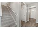 Modern staircase with gray carpeting and a simple white railing at 18051 Dandy Brush Ln, Parker, CO 80134