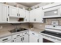 Bright white kitchen with ample cabinetry, built-in microwave, and modern appliances at 750 S Clinton St # 12D, Denver, CO 80247