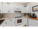 Bright white kitchen with ample cabinetry, built-in microwave, and modern appliances at 750 S Clinton St # 12D, Denver, CO 80247