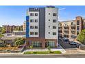 Modern building exterior with brick and light-colored accents, and commercial space on the ground floor at 2881 N Speer Blvd # 202, Denver, CO 80211