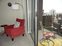 Cozy corner with red armchair and access to a balcony with city views at 1020 15Th St # 26I, Denver, CO 80202