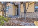 Front entrance with stone accents and a walkway covered in autumn leaves at 7818 Vallagio Ln, Englewood, CO 80112
