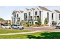 White townhomes with attached garages and green landscaping at 1162 S Reed St, Lakewood, CO 80232