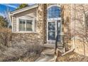 Front entrance with stone detailing and a glass door at 7400 W Grant Ranch Blvd # 43, Littleton, CO 80123