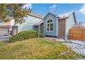 Two-story house with light blue siding, brick accents, and a manicured lawn at 5270 S Yampa Ct, Centennial, CO 80015