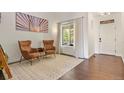 Living room with hardwood floors, two armchairs, and a large window at 385 N Flat Rock St, Aurora, CO 80018