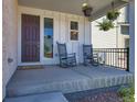 Inviting front porch with rocking chairs, potted plants, and a charming entryway at 147 Silver Rock Trl, Castle Rock, CO 80104