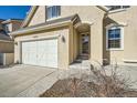 Front entrance with stairs, landscaping, and a white garage door at 15535 W Auburn Ave, Lakewood, CO 80228